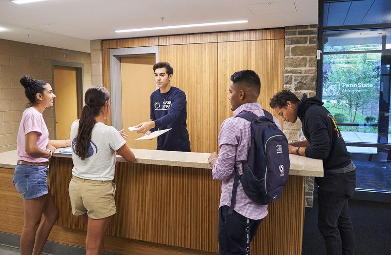students at the front desk of lions gate